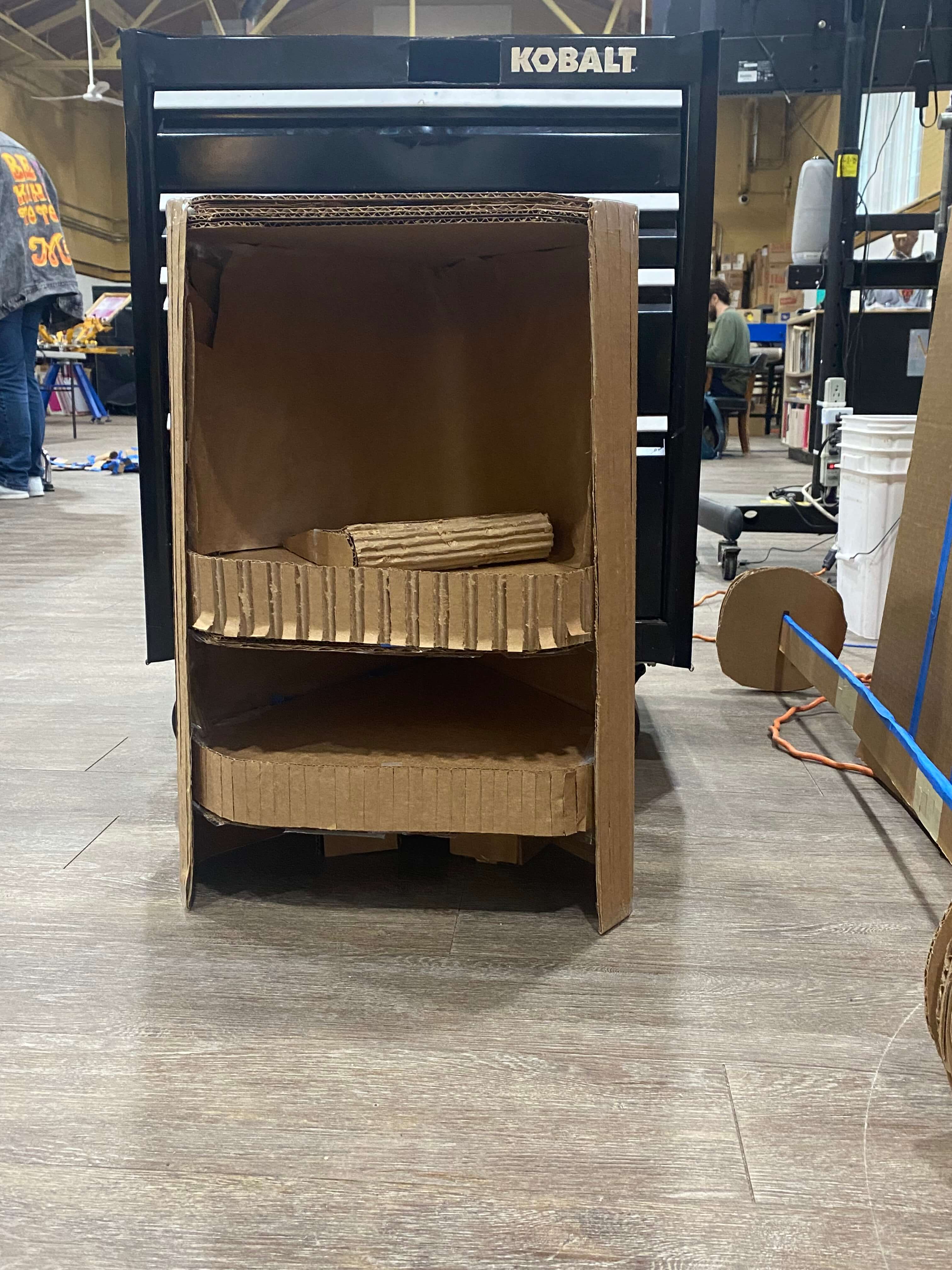A picture of a bookshef made of cardboard, far view.
